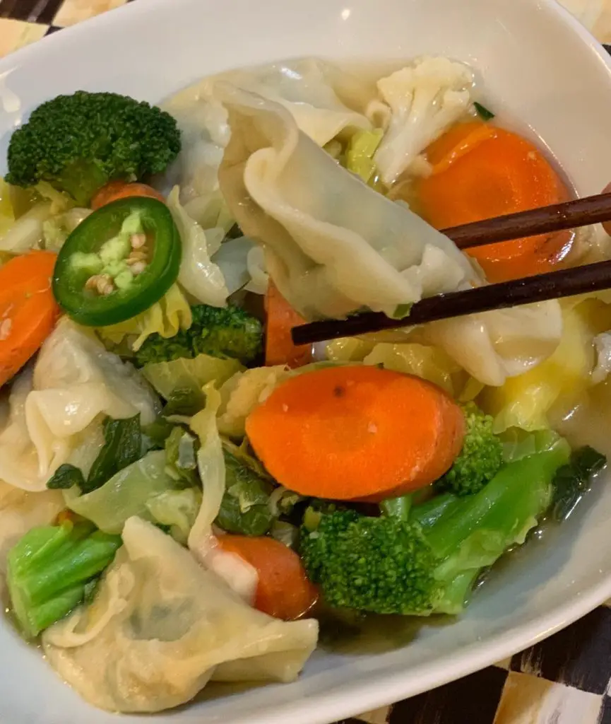 Bowl of easy vegetable potsticker soup full of colorful veggies.