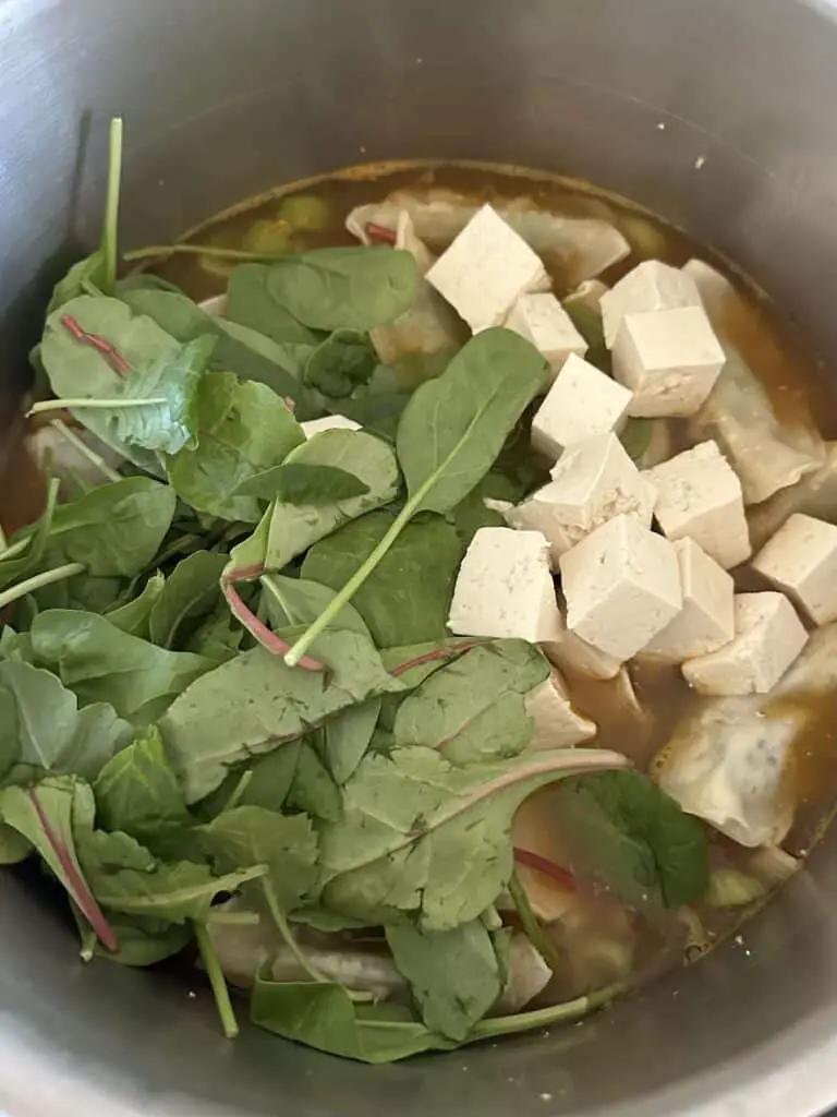 Greens and tofu are added.