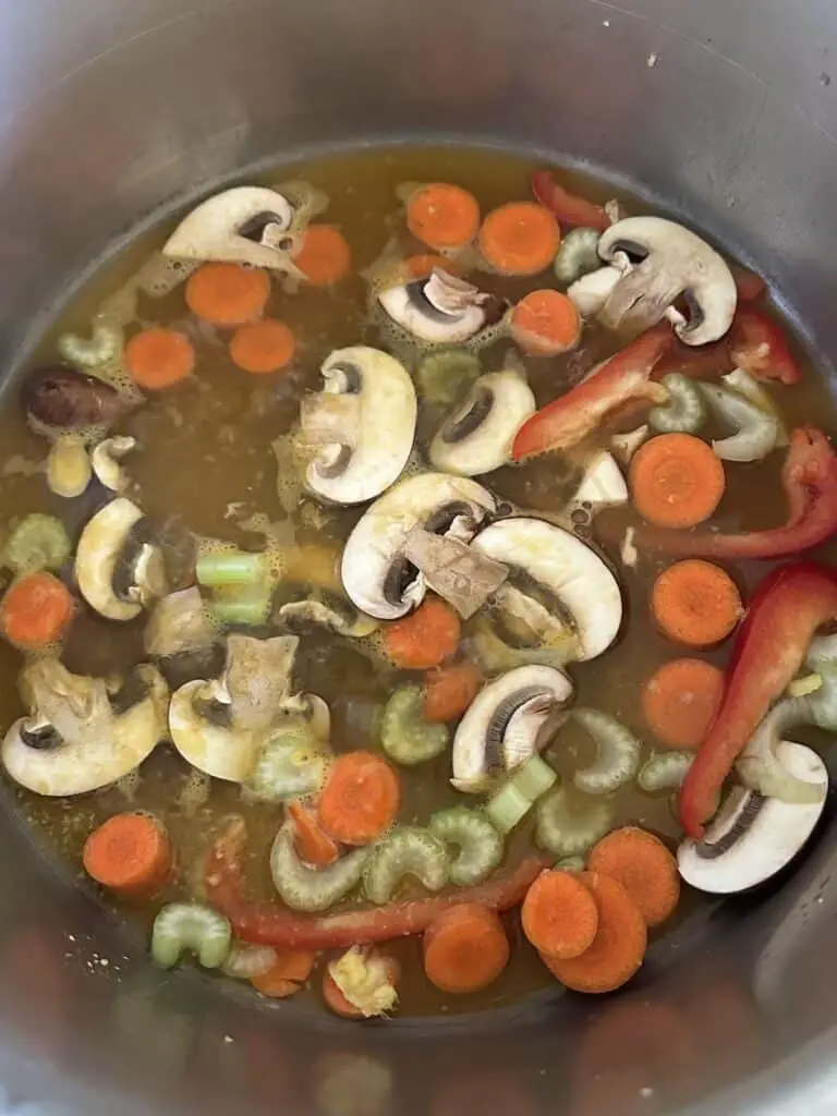 Veggies and broth in pot.