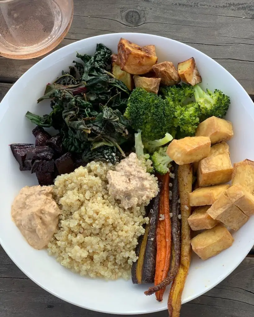 Air fryer tofu without oil in Buddha bowl with roasted carrots, quinoa, broccoli, potatoes, steamed kale, and Bitchin' Sauce.