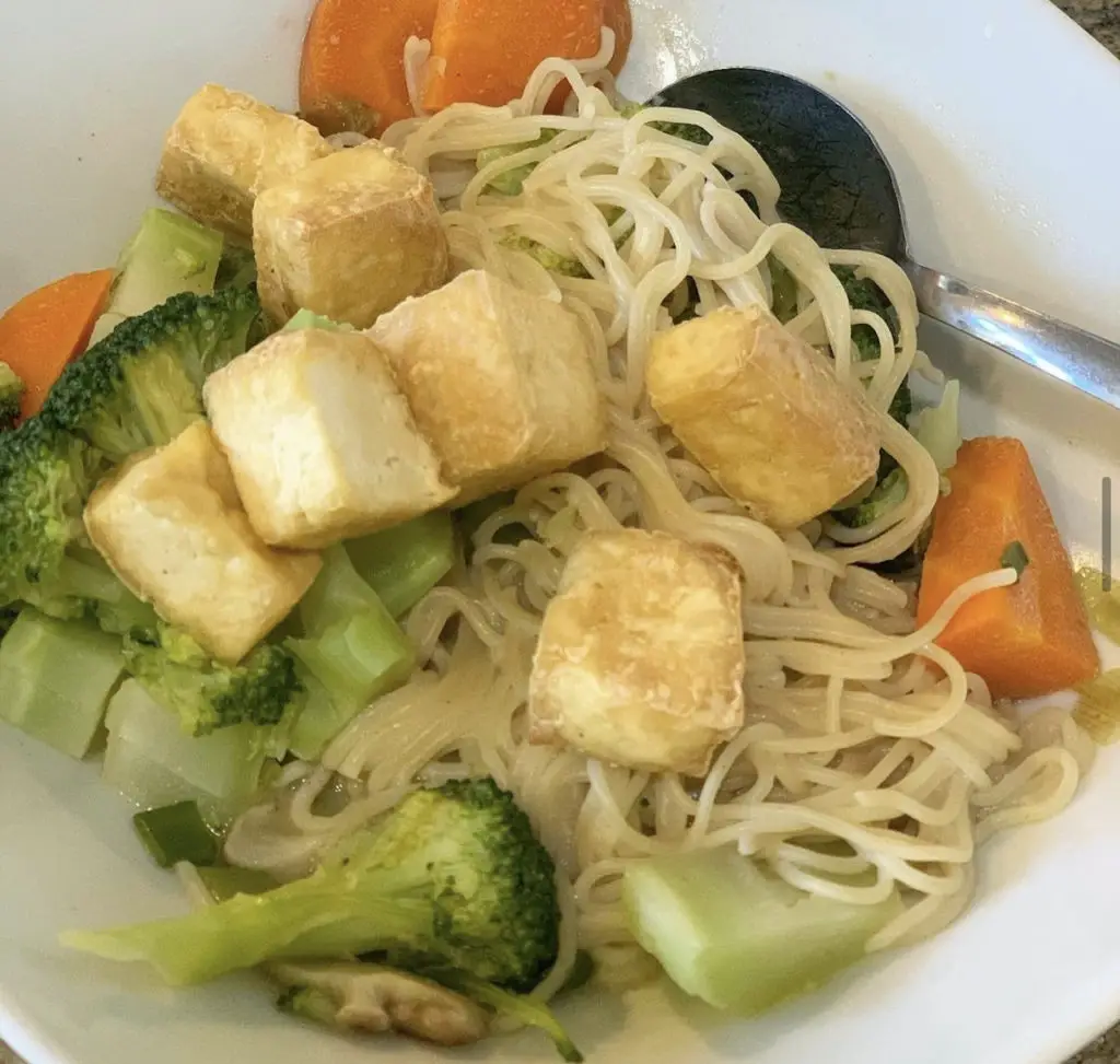 Kid version of ramen bowl with noodles, air fryer tofu, carrots, broccoli, and just a little bit of broth.