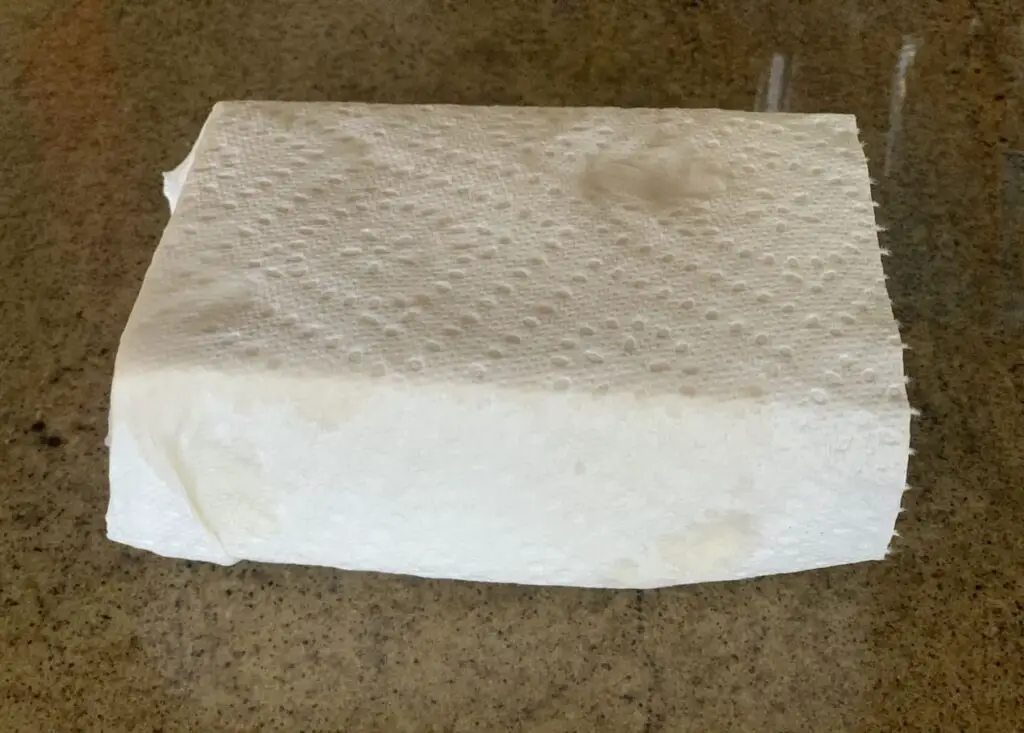 Tofu wrapped in a paper towel.