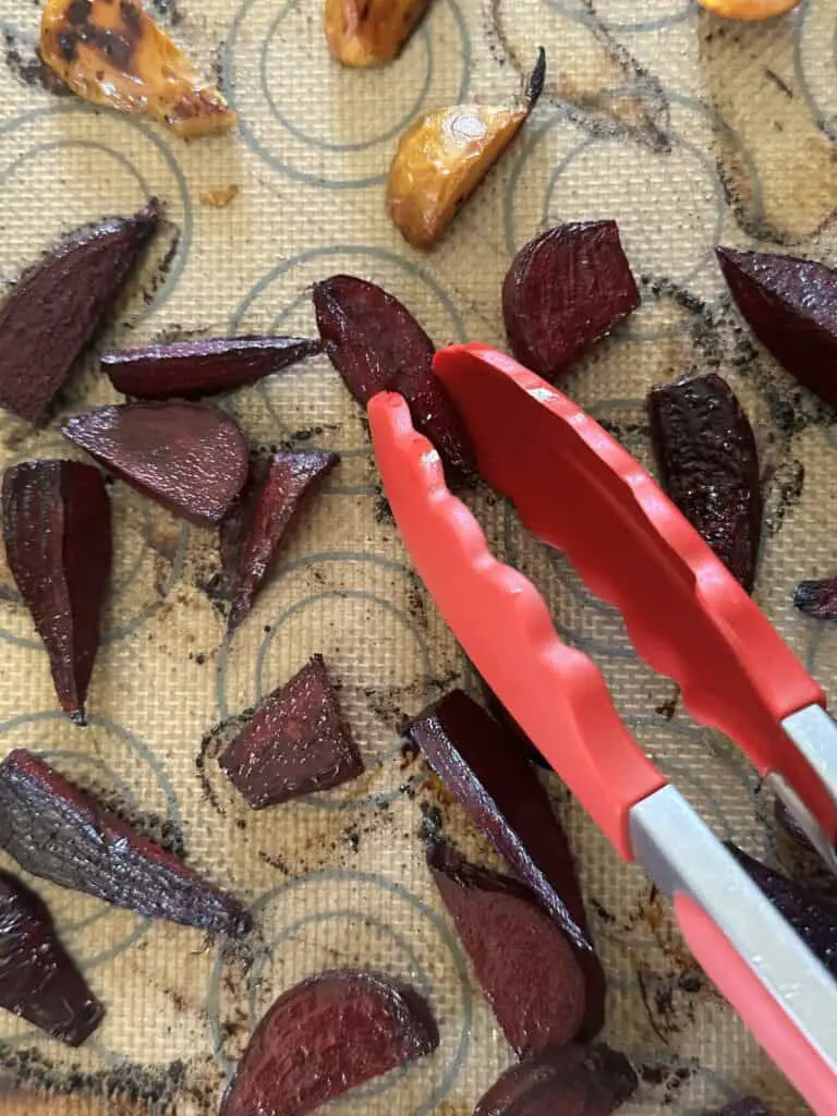 Red and golden beets on silicon baking mat after roasting.