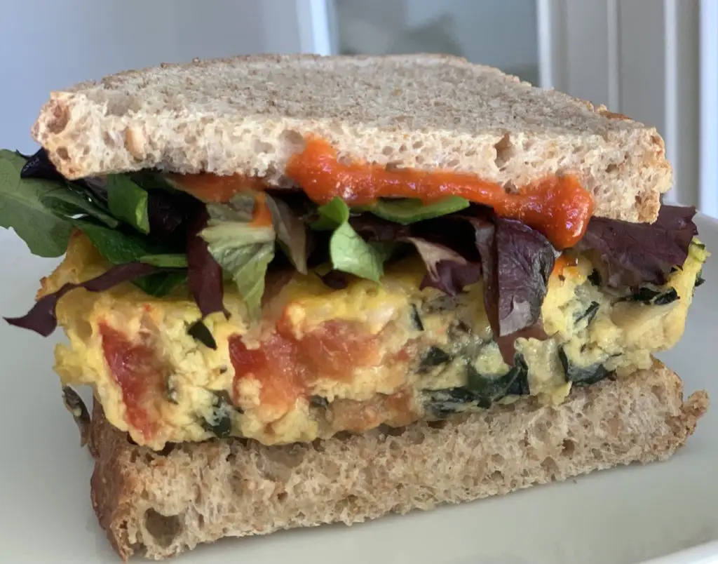 Just egg frittata sandwich with greens and hot sauce.