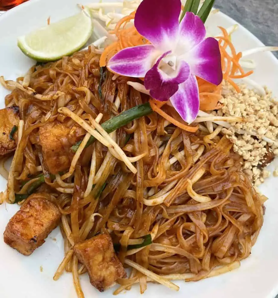 Vegan pad thai garnished with purple orchid flower!