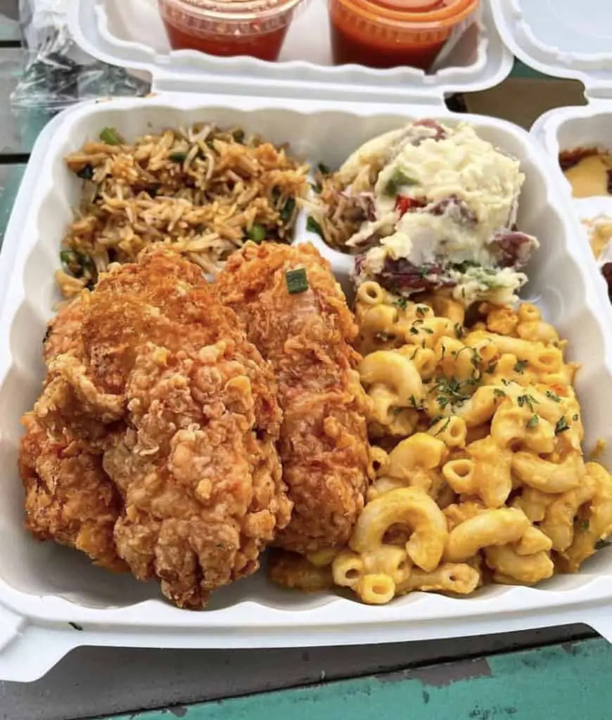 Vegan Mob plate with fried chick'n, smack and cheese, potato salad, and fried rice in a take out container.