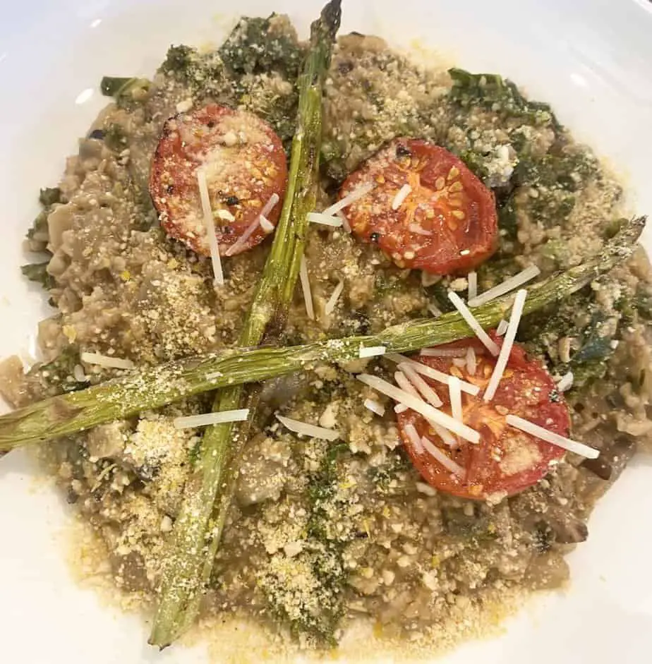 Savory oatmeal with roasted tomatoes and asparagus on top.