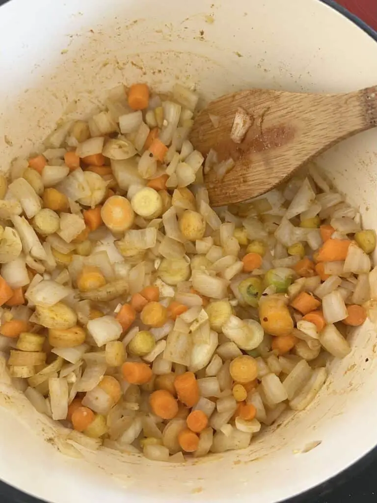 Adding veggies to pot.