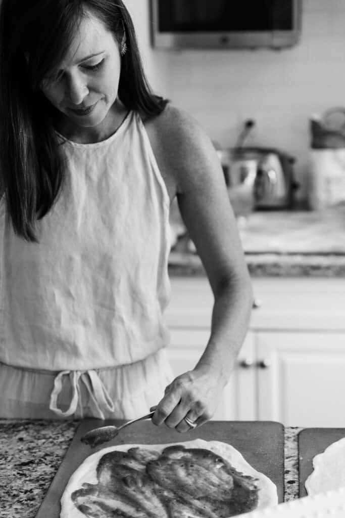Coach Jenn in a black and white action photo cooking in the kitchen.