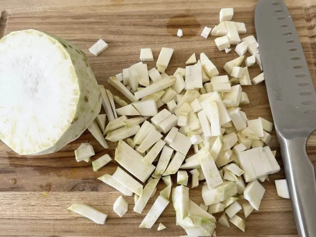 Cutting celery root into half inch chunks.