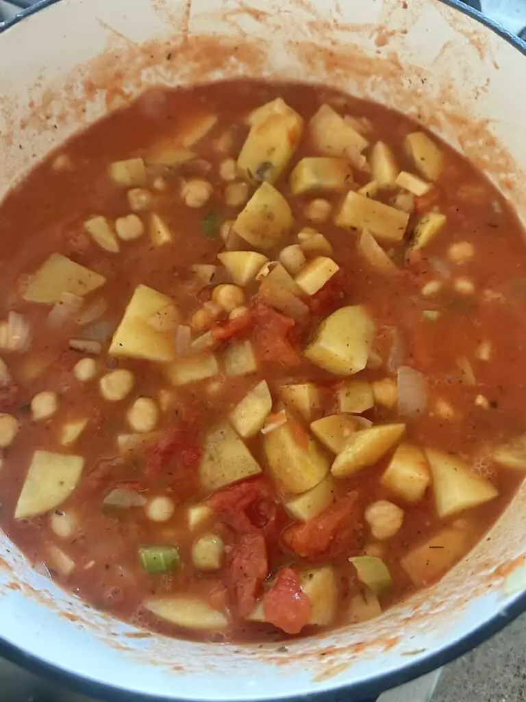 Vegan chickpea soup with potatoes and tomatoes simmering.