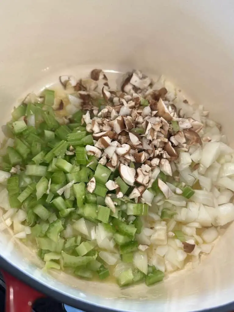 Butter, onions, celery, and mushrooms in a Dutch oven.