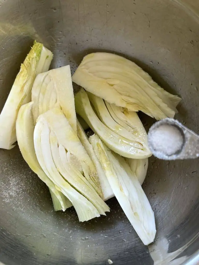 Fennel in bowl combined with oil and salt.