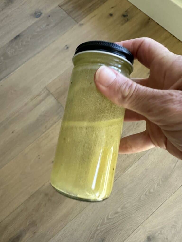 Shaking all dressing ingredients in a jar with lid.