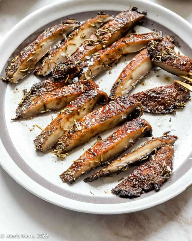 Slices of cooked mushrooms on a plate.