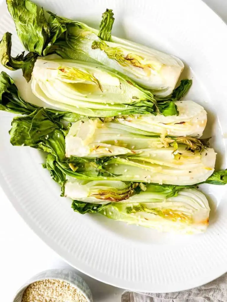 Air fryer bok choy with sesame seeds on top on a plate.