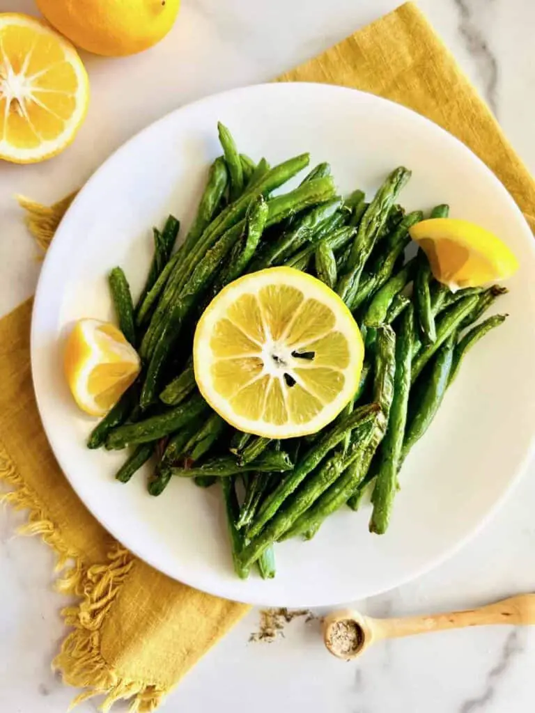 Green beans on a plate with lemon.
