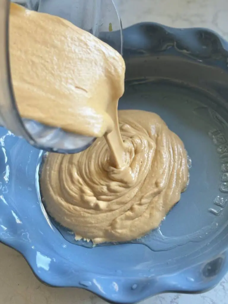 Pouring mixture into baking dish.