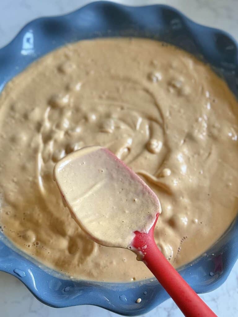 Mixing chickpeas into the creamy dip evenly.
