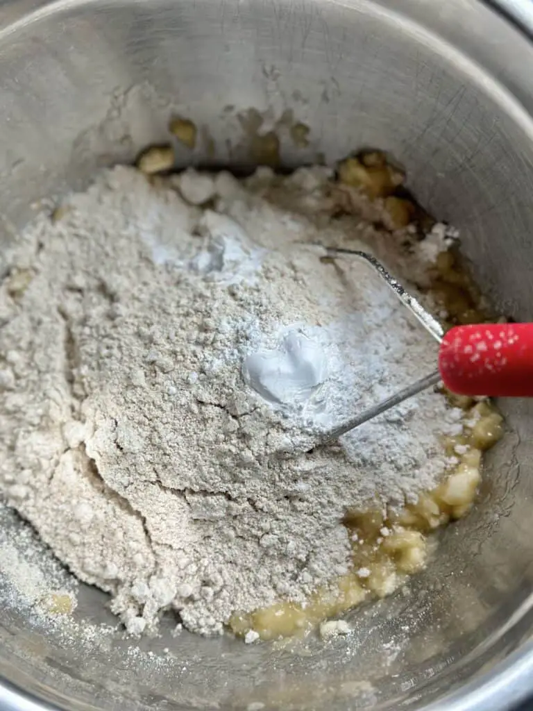 Bowl with mashed banana, oat flour, and baking powder.